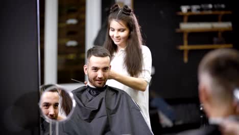 Eine-hübsche-Stylistin-an-den-Haaren-macht-eine-Frisur-für-den-glücklichen-Besucher-des-Salons,-eine-Frau-schneidet-ihr-Haar-mit-einem-Trimmer-Maschine