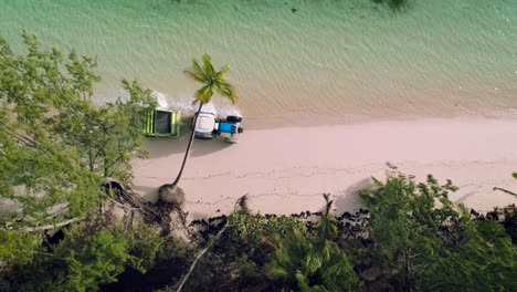 Aerial-video-of-Punta-Cana-beach.-Beach-Sand-Cleaning-Truck,-running-man-and-palm-trees.