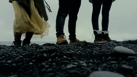 Close-up-view-of-people-foot-standing-on-the-black-volcanic-beach-in-Iceland.-Tourist-exploring-the-island