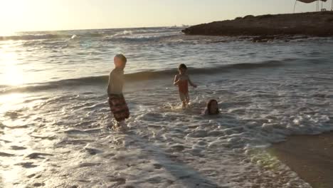 Tres-niños-jugando-en-la-playa-juntos