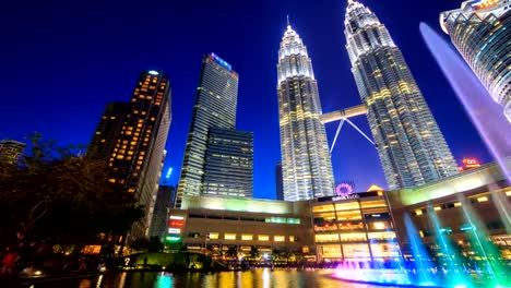 KLCC-PARK,-MALAYSIA---JULY-26-2017-:-Day-to-Night-Twin-Towers-And-KLCC-Park-Symphony-Fountain-Lake-Show-Every-Evening,-Landmark-Travel-Place-of-Kuala-Lumpur,-Malaysia-4K-Time-Lapse-(doly-pan-shot)