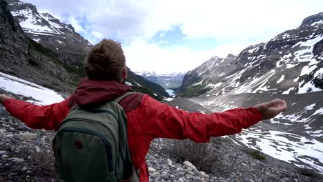 Adventurous-man-arms-outstretched-on-glacier