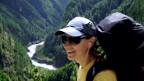 Mädchen-Musikhören-mit-Kopfhörer-auf-dem-Hintergrund-der-Berge