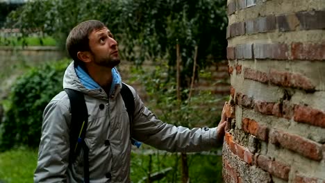 Tourist-touching-holy-walls-of-old-church-praying-about-health-and-protection