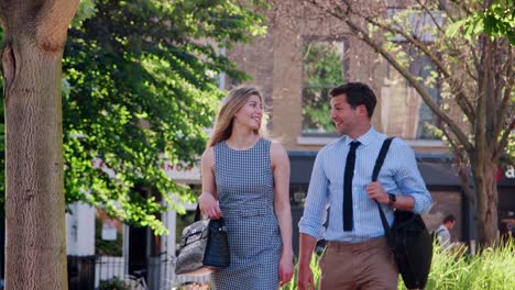 Businessman-And-Businesswoman-Walk-to-Work-Through-City-Park