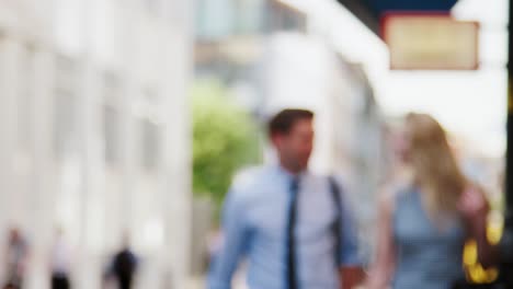 Businessman-And-Businesswoman-Walk-to-Work-Along-City-Street