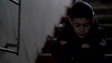 boy-regrets-the-incident,-demolition-house,-boy-sits-alone-in-an-old-ramshackle-building,-winter