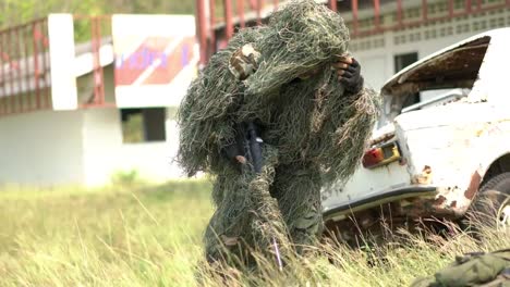 Sniper-soldier-lying-on-the-ground-and-camouflage-in-grass.-Soldier-holding-gun-weapon-and-waring-armor-uniform.-The-military-is-responsible-for-maintaining-the-territory.