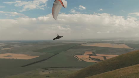 Atleta-paraglider-vuela-en-su-parapente-junto-a-las-golondrinas.-Seguimiento-desde-los-aviones-no-tripulados