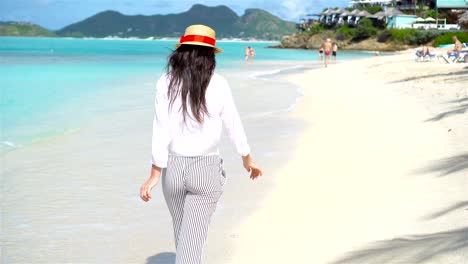 Junge-schöne-Frau-am-tropischen-Strand.-Glückliches-Mädchen-Hintergrund-der-blaue-Himmel-und-türkisfarbenes-Wasser-im-Meer-auf-Karibik-Insel