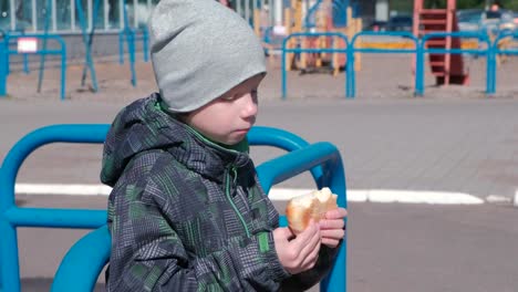 Niño-comiendo-un-bollo-en-el-patio.