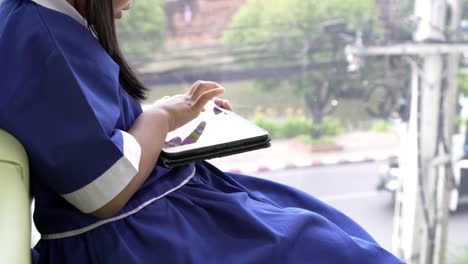 Asian-little-pupil-playing-writing-on-smartphone-at-the-cafe