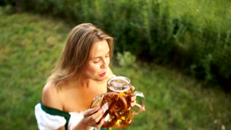 Young-sexy-girl-in-a-traditional-Bavarian-dress-buys-beer-and-pretzel-at-the-Oktoberfest-beer-festival.-A-woman-laughs-cheerfully-and-enjoys-buying.-On-a-green-background