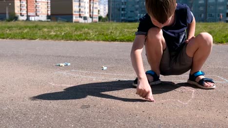 Junge-zieht-mit-blauer-Kreide-auf-dem-Asphalt.-Close-up-Hände.