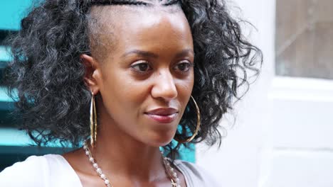 Fashionable-young-black-woman-looking-to-camera,-close-up-head-shot