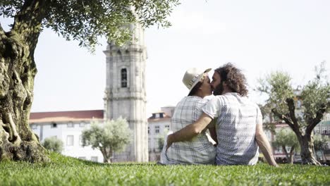 Couple-kissing-near-tree-on-grass-in-park