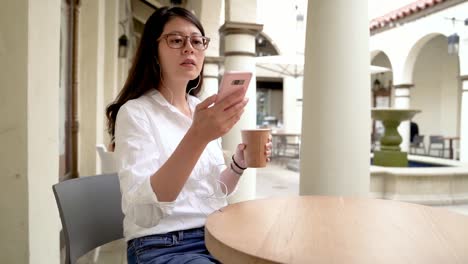 mujer-sentada-en-una-cafetería-y-mensajes-de-texto.