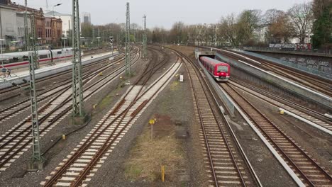 subway-drives-into-the-central-station-and-train-is-leaving-station,-Hamburg,-Germany