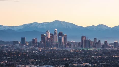 Die-Innenstadt-von-Los-Angeles-mit-Snowy-Mountains-bei-Sonnenaufgang-Timelapse