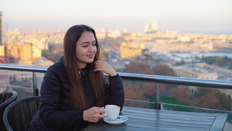 Dama-bebiendo-café-en-un-café-al-aire-libre-con-impresionantes-vistas-de-barcelona