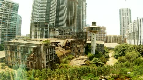 old-destroied-house-in-the-middle-of-skyscrapers-view-through-glass-Bombey