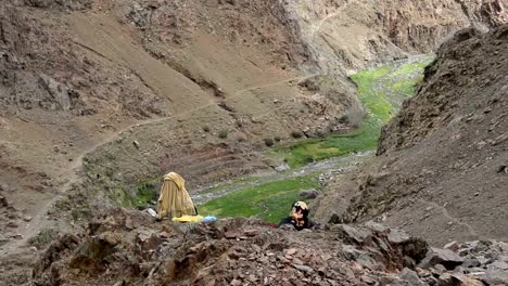 Dos-mujeres-en-vestido-tradicional-de-Marruecos-en-vestidos-de-sentado-en-un-borde-del-acantilado