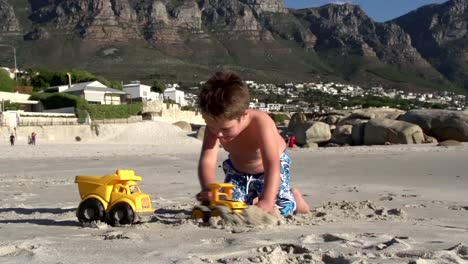 Young-boy-playing-with-toys-on-beach,-Cape-Town,South-Africa