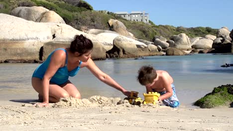 Mutter-und-Kind-spielen-mit-Spielzeug-am-Strand,-Cape-Town