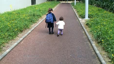 Young-sister-walks-with-her-older-sister-to-school