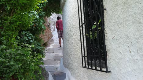 Un-solo-hombre-caminando-a-estrechas-calles-de-Plaka,-Atenas,-Grecia