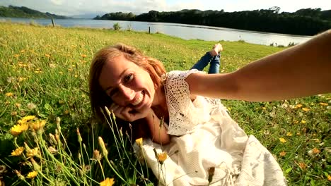 Joven-mujer-lleva-un-selfie-en-un-prado-de-flores-silvestres