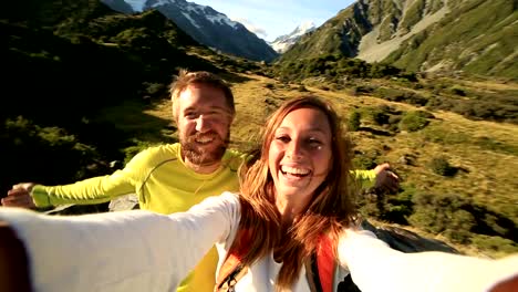 Young-couple-take-self-portrait-on-mountain-background