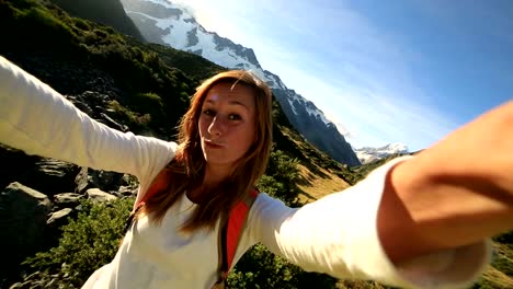 Young-woman-takes-self-portrait-on-mountain-background