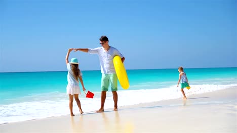 Familia-feliz-divirtiéndose-en-playa-tropical