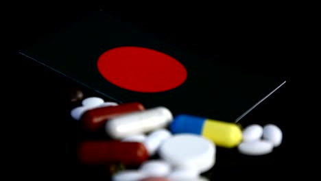 Bangladesh-flag-with-lot-of-medical-pills-isolated-on-black-background