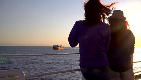 Silhouette-der-jungen-attraktiven-Freunde-romantischer-Sonnenuntergang-am-Kreuzfahrt-Schiff-im-Meer