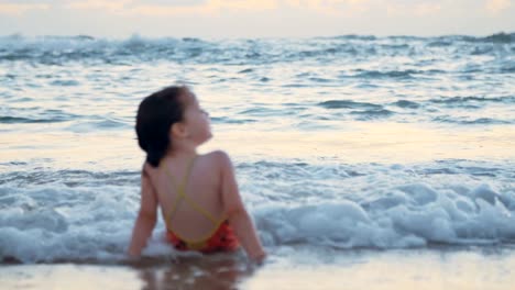 Kleine-Mädchen-spielen-am-Strand-im-Wasser-während-Sonnenuntergang-Stunde