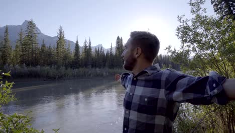 Man-arms-outstretched-in-nature-by-the-river