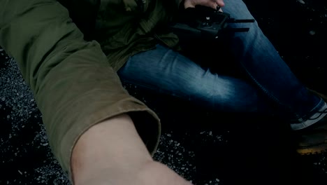 Close-up-aerial-view-of-the-male-feet-in-boots-on-black-volcanic-beach-in-Iceland.-Cameraman-catching-copter-in-hand