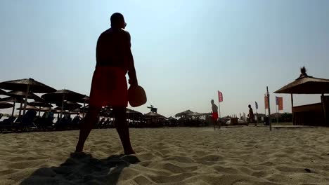 Vater-und-Sohn-Silhouetten-Tennis-spielen-gemeinsam-am-Strand