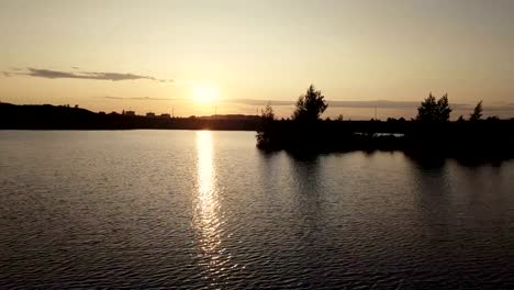 Aerial-shooting-from-flying-drone-water-surface-river-on-background-sunset