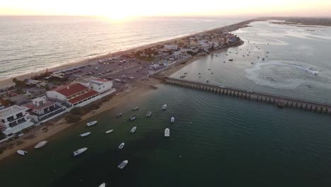 Fliegen-über-dem-Faro-Strand-(Praia-de-Faro)-bei-Sonnenuntergang,-Algarve,-Portugal