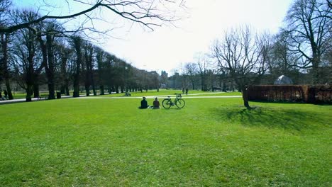 Copenhagen-Stadtpark-am-sonnigen-Tag,-Menschen-im-Urlaub-entspannend-auf-dem-grünen-Rasen