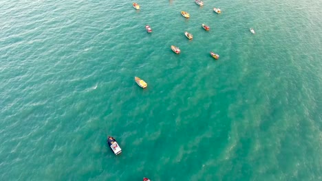 Aerial-view-of-boats-navigating-around-rock-pillars-in-the-sea-in-Portugal.