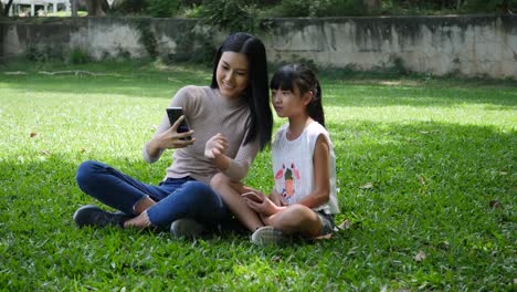 Young-mother-and-little-child-daughter-take-a-photo-selfie-from-smartphone-or-cellphone