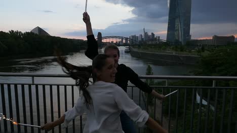 Young-Women-Having-Fun-With-Sparklers-on-City-Bridge-2