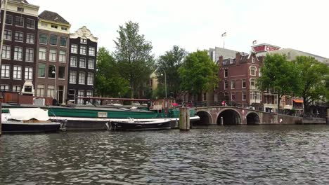 iconic-boat-view-of-the-canal-and-traditional-bridge-in-Amsterdam,-Holland-Europe