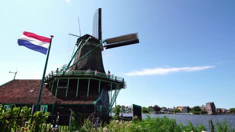 Tourists-couple-taking-pictures-of-traditional-Windmills-at-the-Zaanse-Schans-near-Amsterdam,-Holland