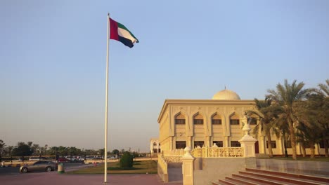 Die-Vereinigten-Arabischen-Emirate-Fahnenschwingen-in-Sharjah-Stadt-bei-Sonnenuntergang