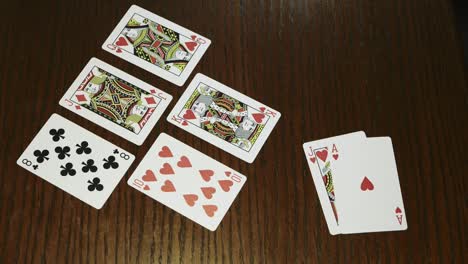 hands-holding-shuffle-playing-card-deck-on-wooden-table